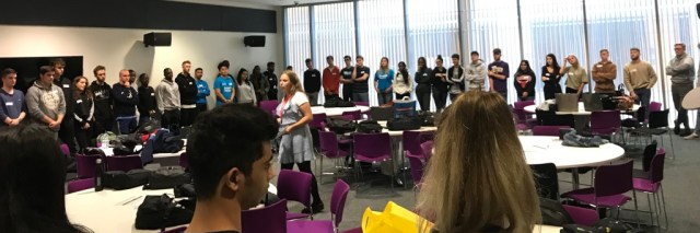 University students stood around the edge of a large classroom taking part in a step in circle